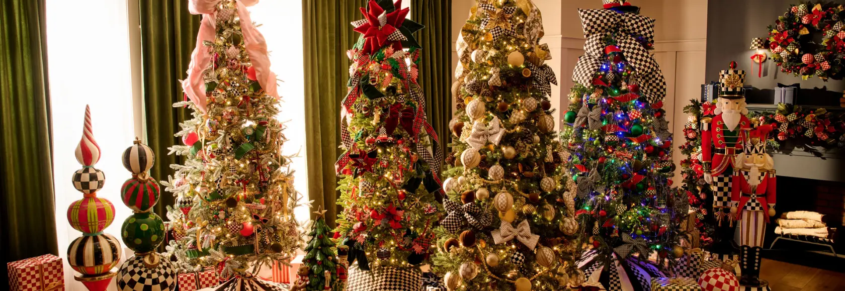 A row of Christmas trees decorated with MacKenzie-Childs ornaments