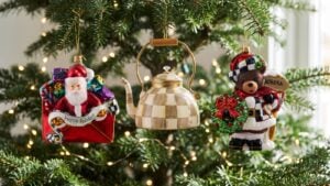 MacKenzie-Childs Mocha Check Tea Kettle, Christmas Letter Santa and Aurora Teddy Bear glass ornaments hanging on a lit Christmas tree